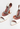 Amina Muaddi heels in white patent leather with crystal and "AWGE” logo charm - material/texture close-up