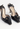 Chanel vintage Camellia heels inblack leather with camellia flower and a golden CC-embossed button - angled view
