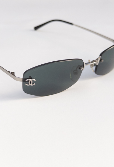 Prada vintage rimless sunglasses in dark bottle green oval lenses with with sculptural silver-tone arms with "CC" hardware - material/texture close-up